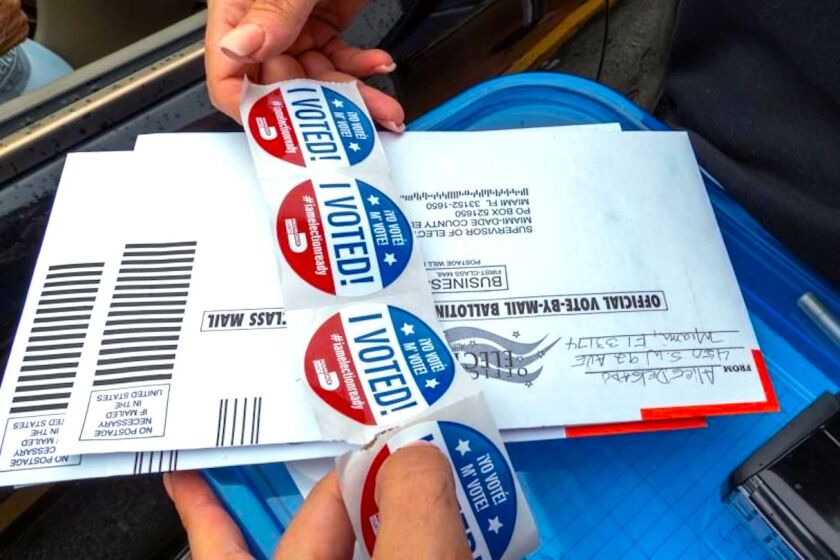 Etiquetas que dicen "Yo voté" se entregan a las personas tras votar en la puerta de un centro de votación en Miami