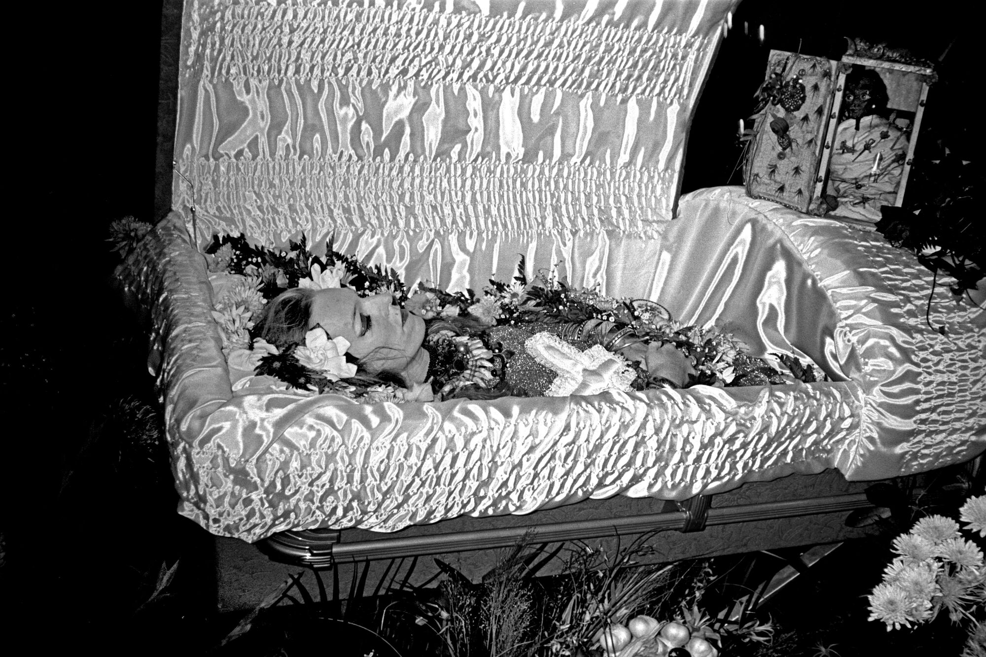 A black-and-white photo of a woman in an open casket 