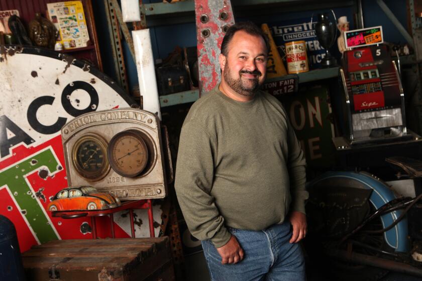 Frank Fritz in an olive green shirt and jeans posing in a workshop