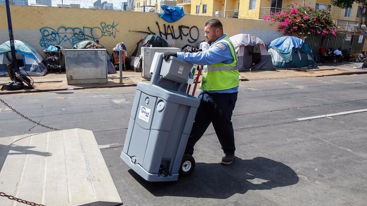 Edwin Gonzalez of United Site Services delivers a portable hand-washing station to the Neil Good Day Center in downtown San Diego on Friday.