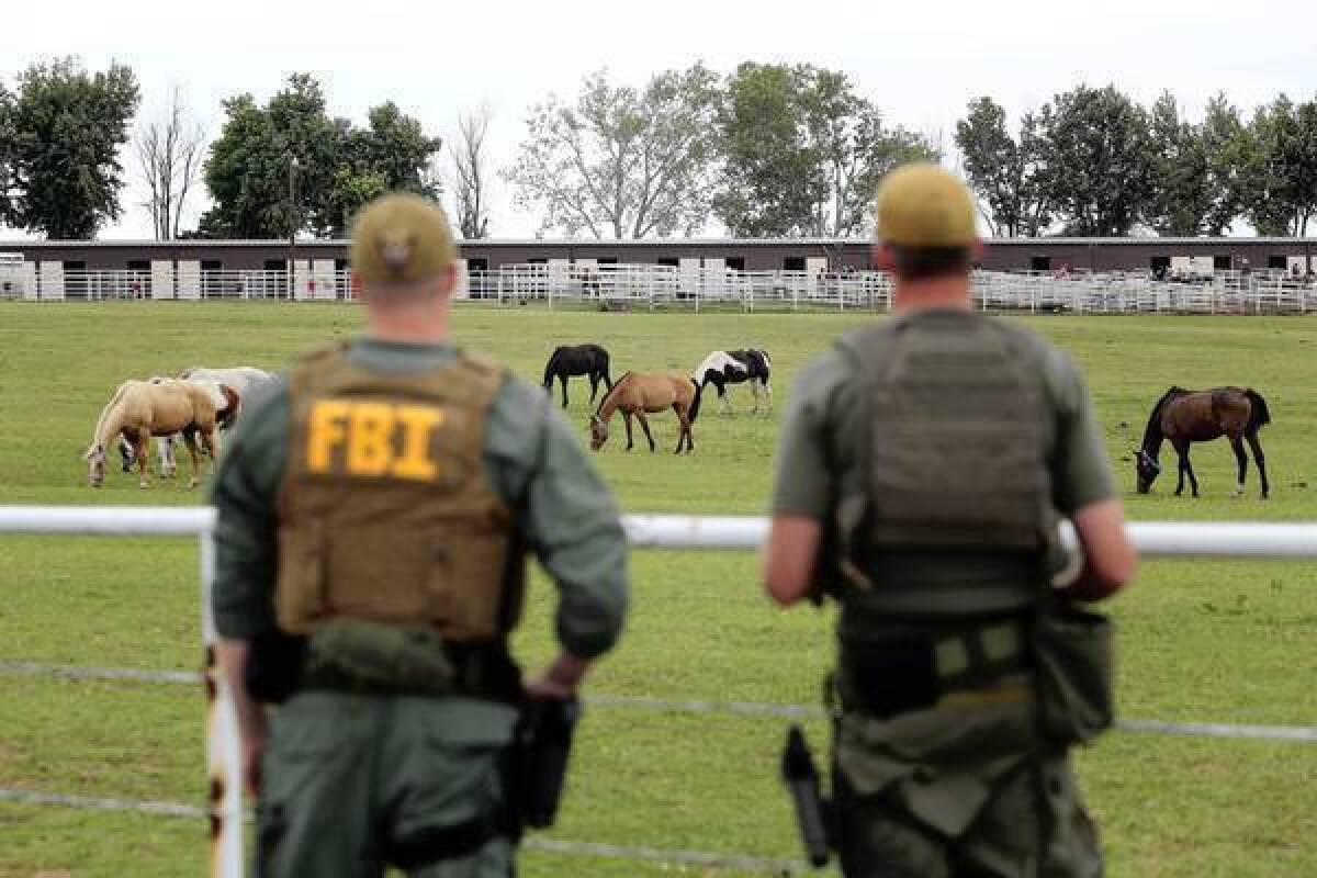 FBI agents look over a horse ranch in Lexington, Okla., that was raided as part of an investigation of alleged money laundering by Mexico's largest drug cartel.