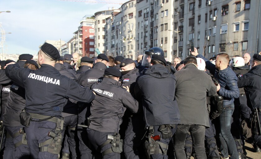 Serbian police officers and protesters clash during a protest in Belgrade, Serbia, Saturday, Nov. 27, 2021. Skirmishes on Saturday erupted in Serbia between police and anti-government demonstrators who blocked roads and bridges in the Balkan country in protest against new laws they say favor interests of foreign investors devastating the environment. (AP Photo/Milos Miskov)