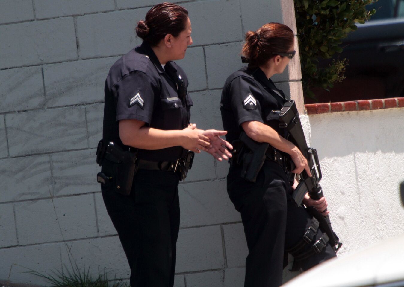 Armed LAPD officers take up position on Hartsook Street in North Hollywood after a man who led police on a high-speed chase on several freeways Monday was roaming around a neighborhood armed with an assault rifle Monday.