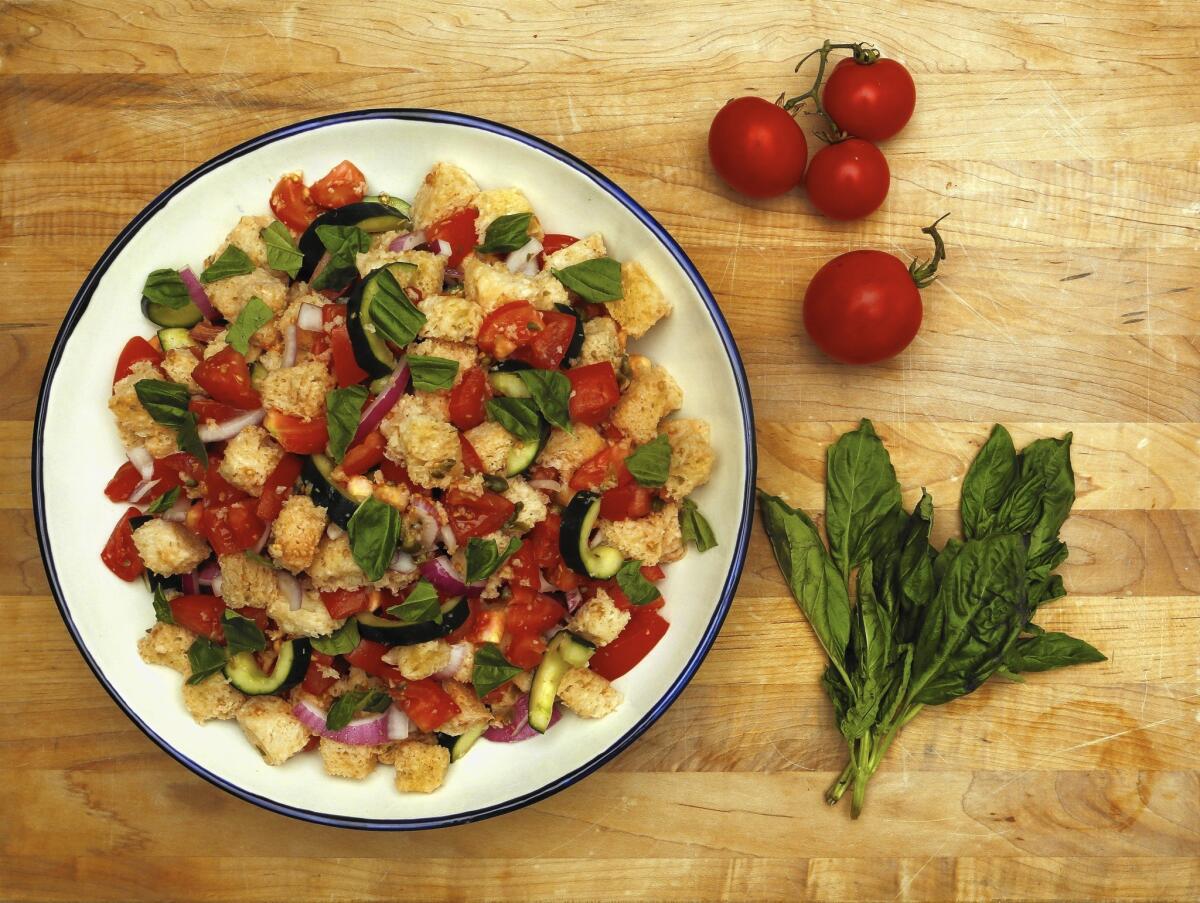 Panzanella, a Tuscan summer salad, is a cinch with stale bread and ripe tomatoes. Combine with cucumbers, onions and a vinaigrette.