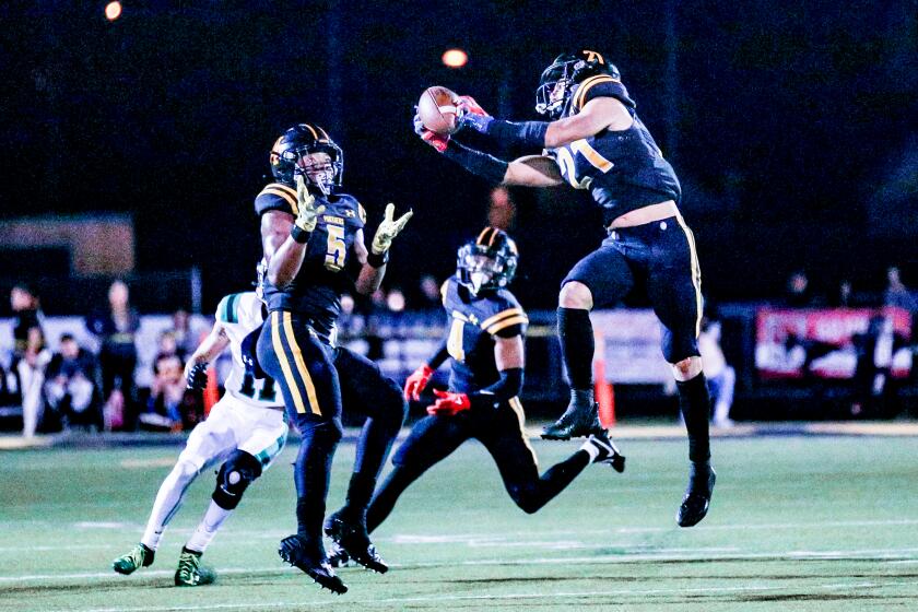 Shane Rosenthal of Newbury Park comes up with interception against Thousand Oaks with Jaden Mack looking on.