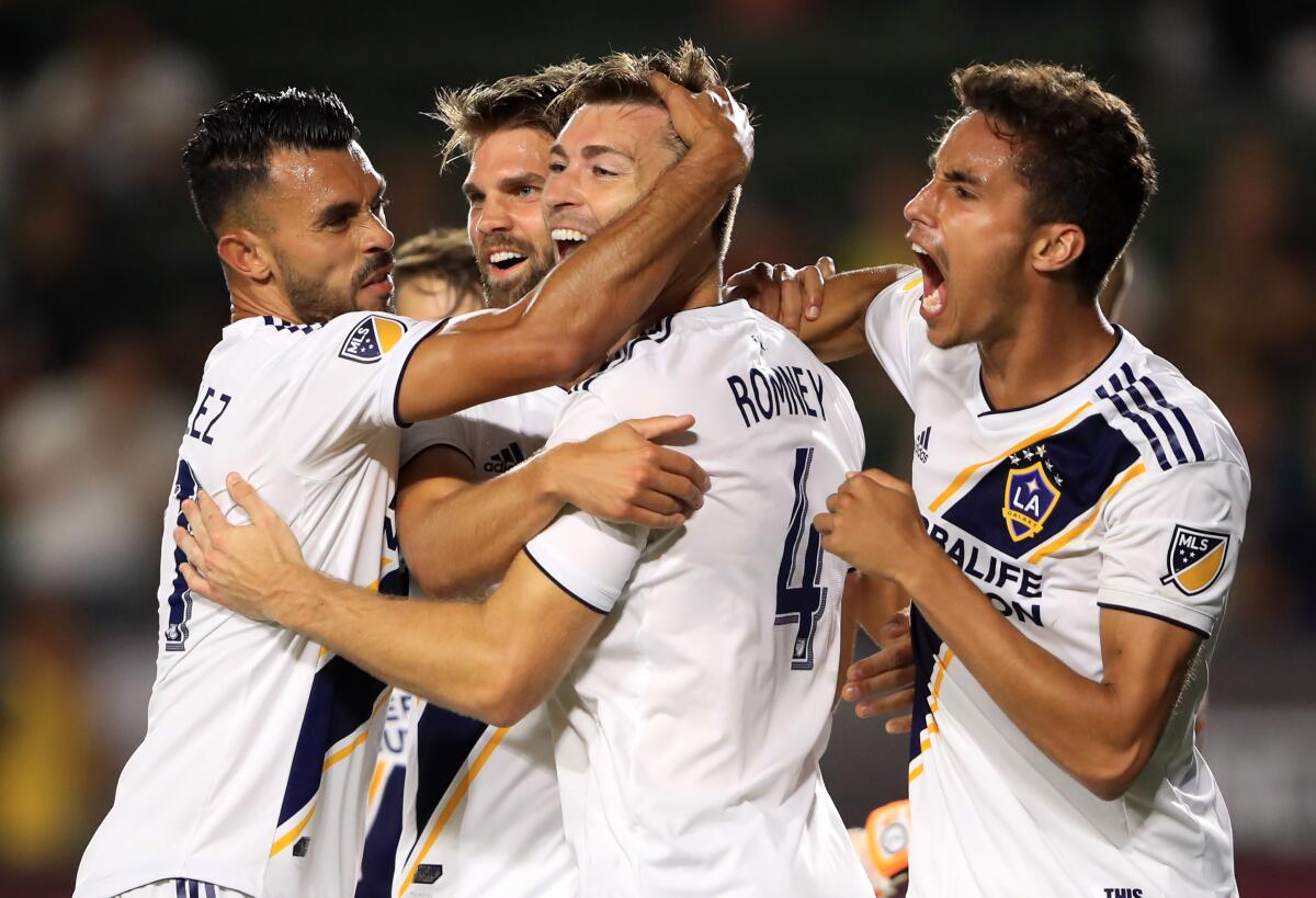 Galaxy defender Dave Romney (4) is congratulated by teammates after scoring against Tijuana.