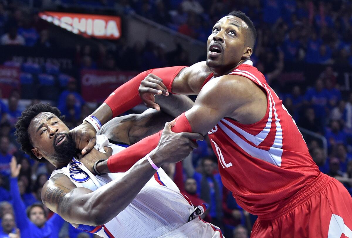 Clippers center DeAndre Jordan, left, and Houston center Dwight Howard get tangled under the basket while battling for rebounding position during a game May 14 at Staples Center.