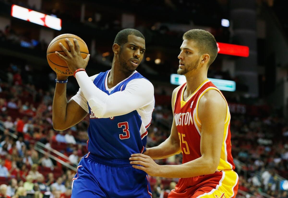 Clippers point guard Chris Paul, left, tries to work his way past Houston Rockets small forward Chandler Parsons during the first half of the Clippers' 118-107 win Saturday. The Lakers play the Clippers for the final time this season Sunday.