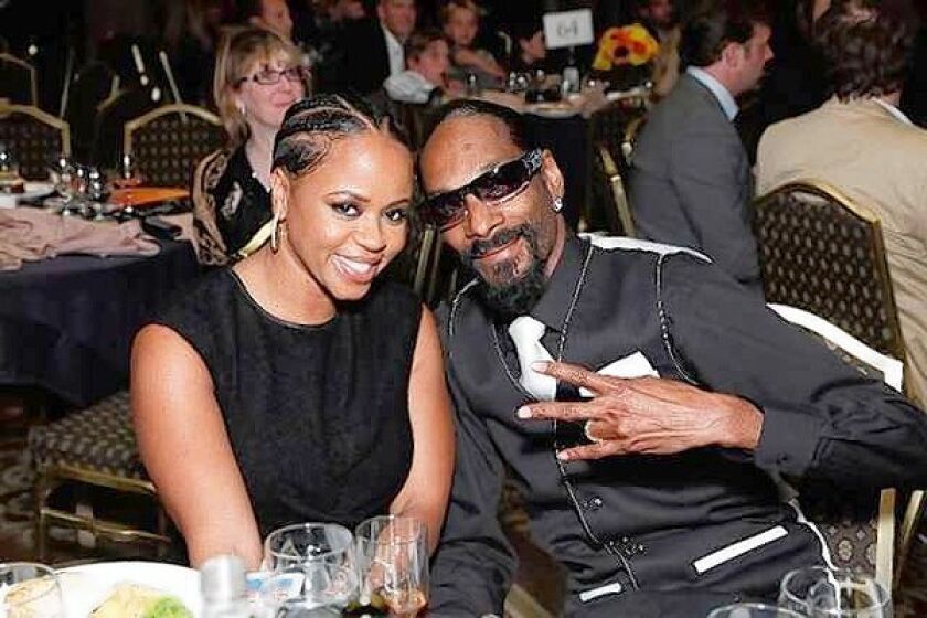 Shante Broadus and husband Snoop Dogg cozy up at the Harold Pump Foundation's anniversary gala.