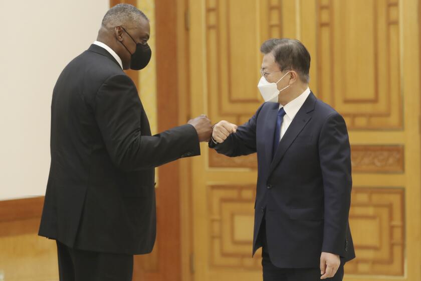 South Korean President Moon Jae-in, right, bumps elbows with U.S. Defense Secretary Lloyd Austin before their meeting at the presidential Blue House in Seoul, South Korea, Thursday, Dec. 2, 2021. Austin said Thursday that China's pursuit of hypersonic weapons "increases tensions in the region" and vowed the U.S. would maintain its capability to deter potential threats posed by China. (Ahn Jung-hwan/Yonhap via AP)