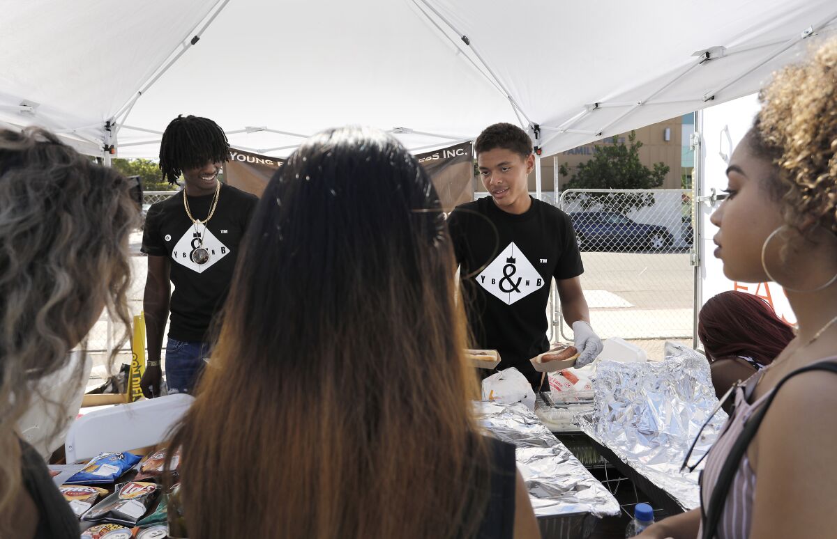 Abdula Randle, left, 20, and Larren Colum Jr., 18, work the Young Black & 'N Business food tent at the Summer Y.E.S. Fest at Fair@44.