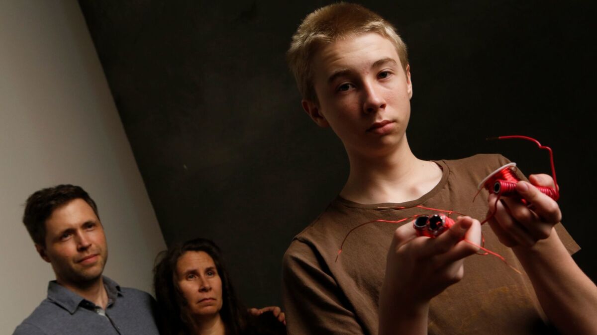 Rogan Ferguson, left, and Susan Ferguson with their son, Asa, who holds the pieces of coil "gun" science project that got his teacher into trouble in 2014.