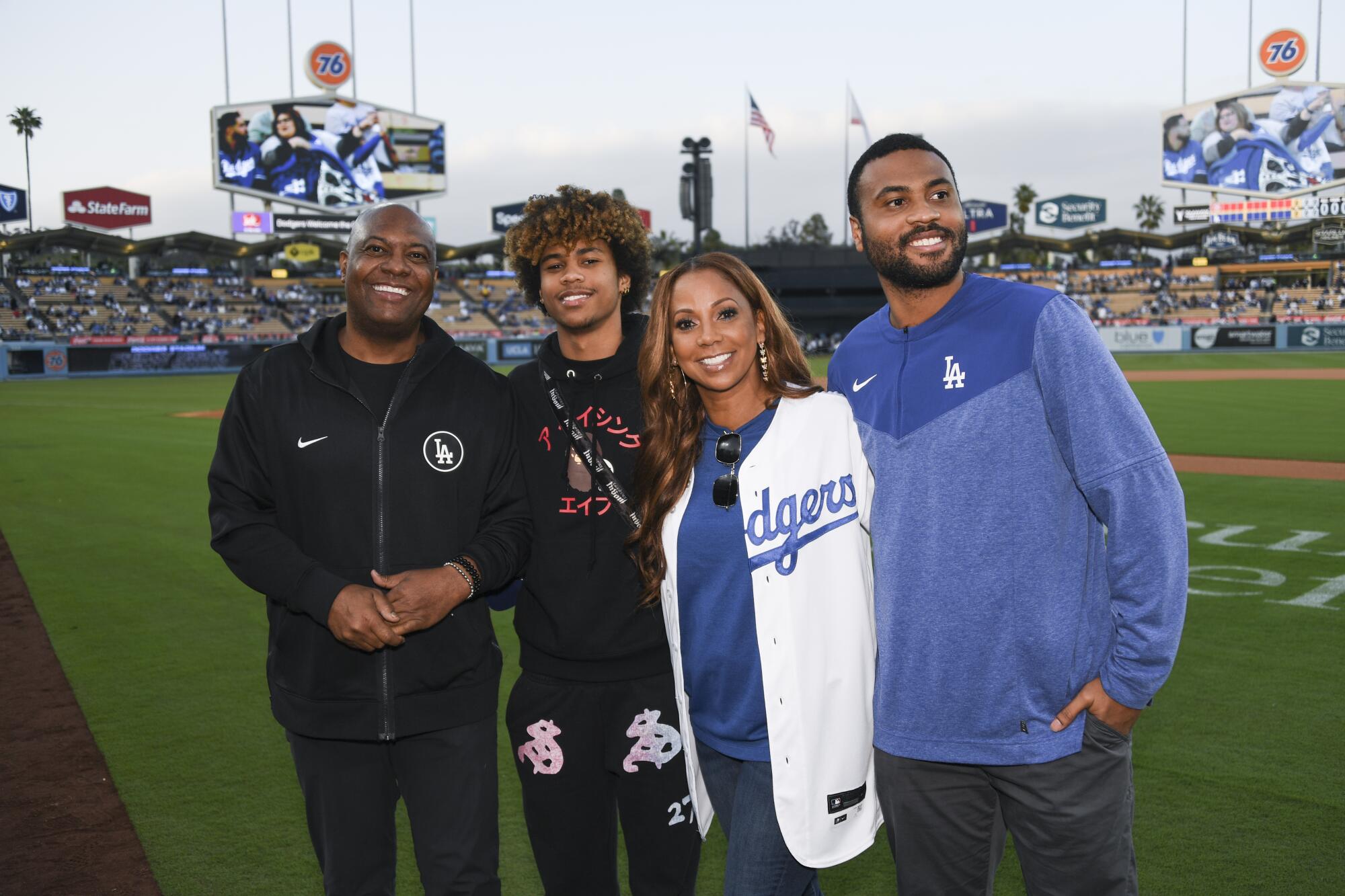 Rodney Peete, Roman Peete, Holly Robinson-Peete and RJ Peete stand on the field at Dodger Stadium.