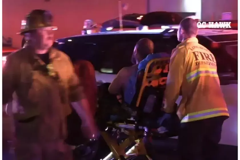 Firefighters take a man to an ambulance after a shooting Saturday night in Long Beach. (Photo by OC HAWK)