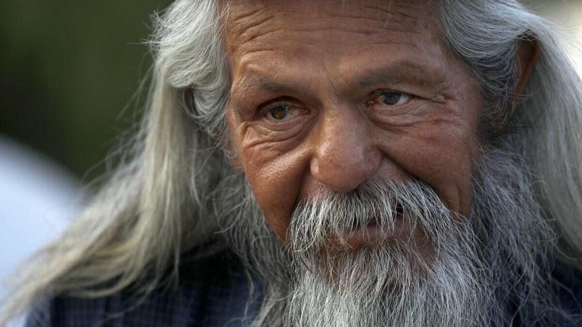 Benito Moreno, 59, waits in line for dinner to be served outside Our Lady Queen of Angels Catholic Church, located near the new emergency shelter.