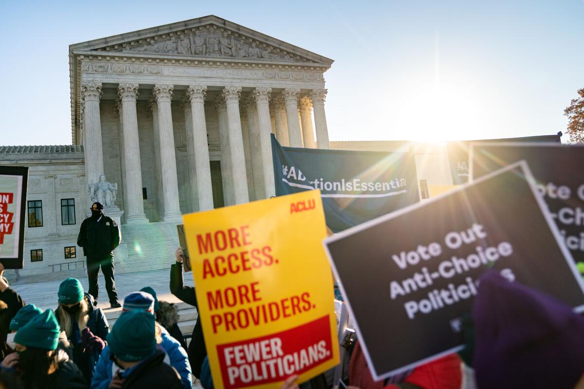Protesters hold up signs supporting abortion rights in front of the U.S. Supreme Court.