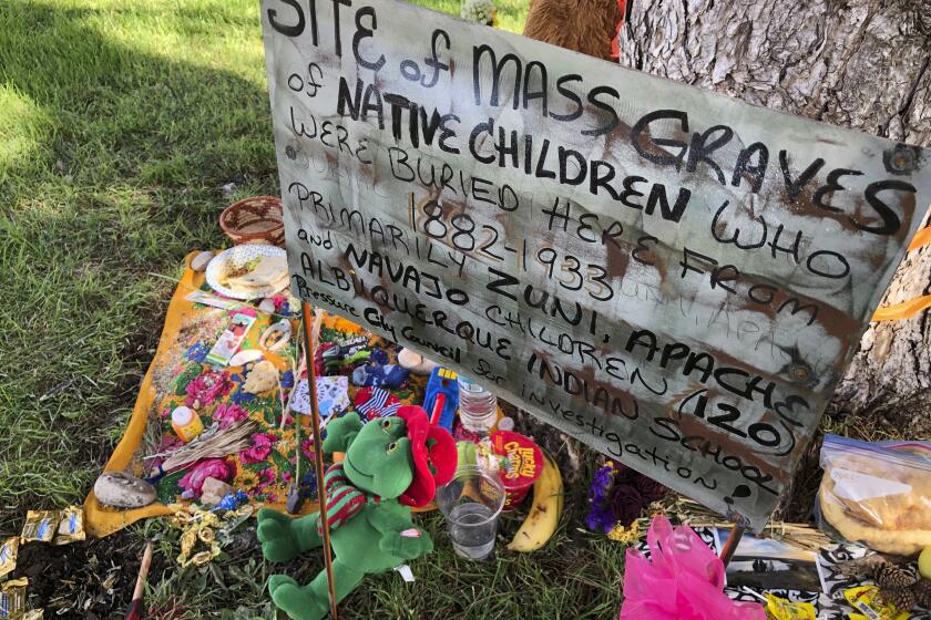 FILE - A makeshift memorial for the dozens of Indigenous children who died more than a century ago while attending a boarding school that was once located nearby is displayed under a tree at a public park in Albuquerque, N.M., on July 1, 2021. The U.S. Interior Department is expected to release a report Wednesday, May 11, 2022, that it says will begin to uncover the truth about the federal government's past oversight of Native American boarding schools. (AP Photo/Susan Montoya Bryan, File)
