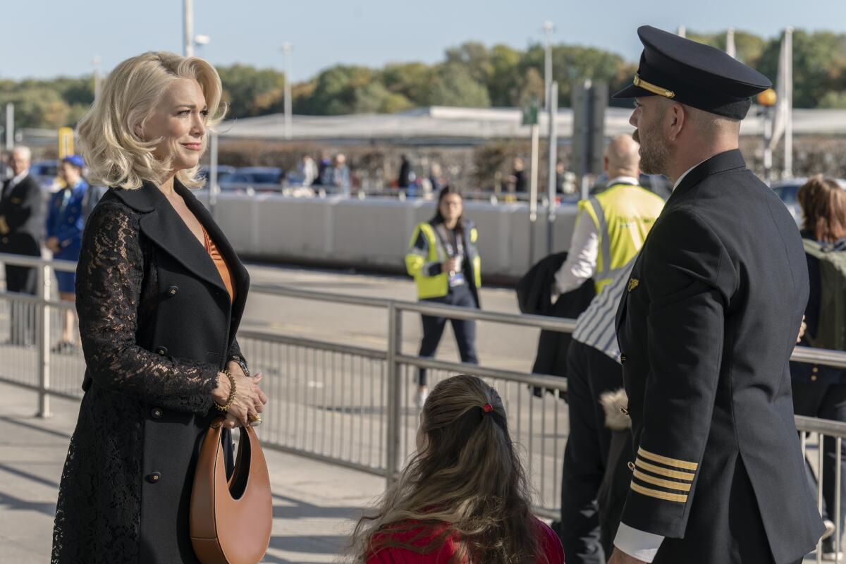 In a scene from "Ted Lasso," Rebecca looks at a pilot who is with a little girl at the airport.