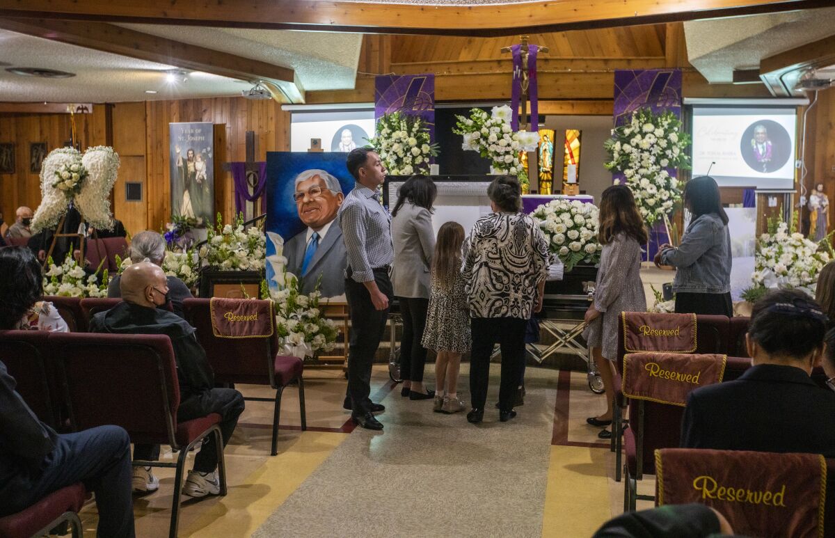 People pay their respects to Tom Rivera at San Salvador Church in Colton.