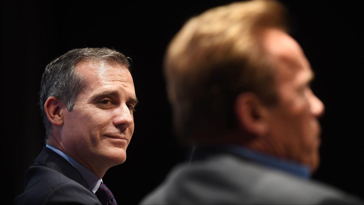 Los Angeles Mayor Eric Garcetti, left, and Former Governor Arnold Schwarzenegger participate in a conversation about climate change at the Ray Kurtzman Theater in Los Angeles.