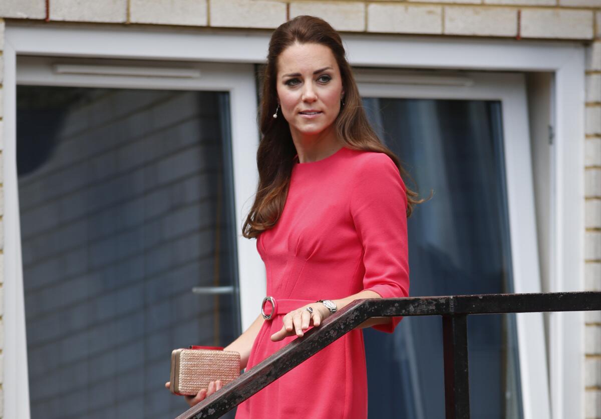 The Duchess of Cambridge leaves the Blessed Sacrament School in London, wearing a coral-colored dress by Goat and carrying an L.K. Bennett clutch.