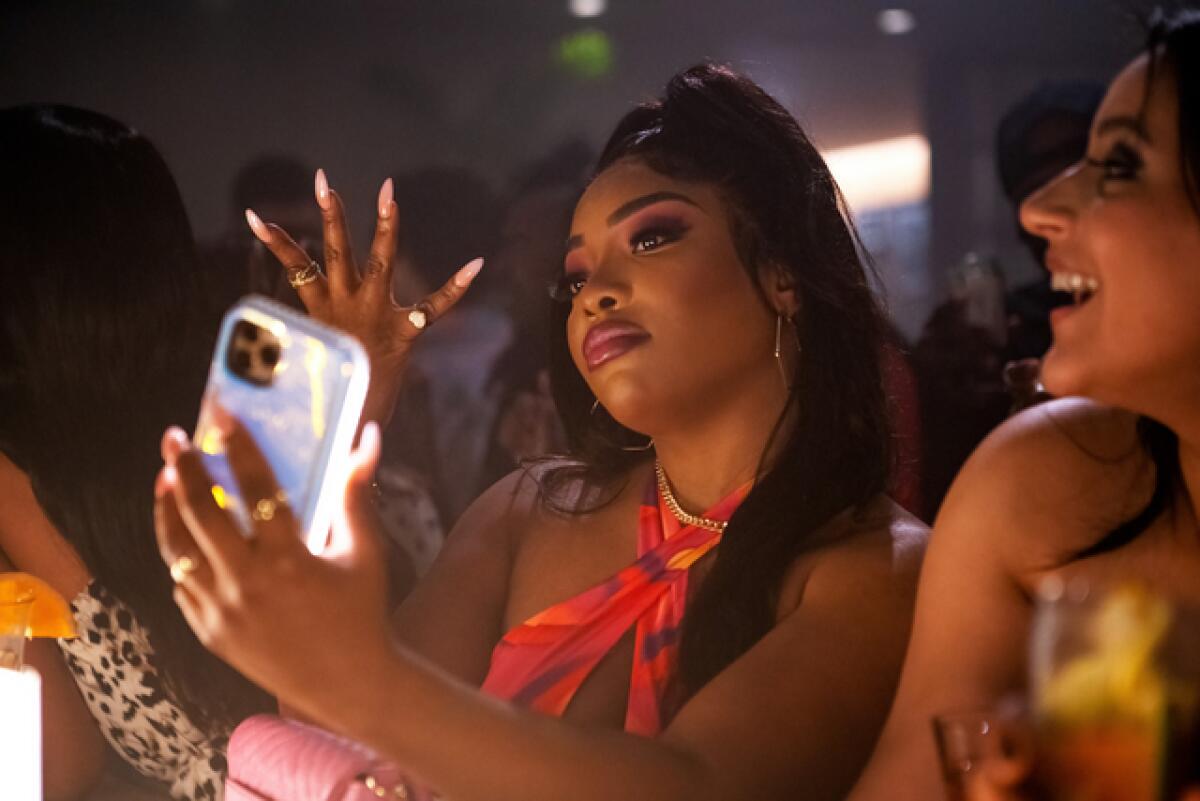 A woman poses for a selfie at a bar