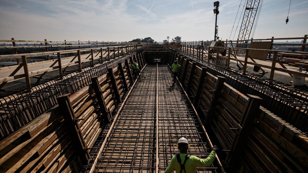Construction workers at a viaduct being built to extend over State Route 99 and North and Cedar Avenues in Fresno County.