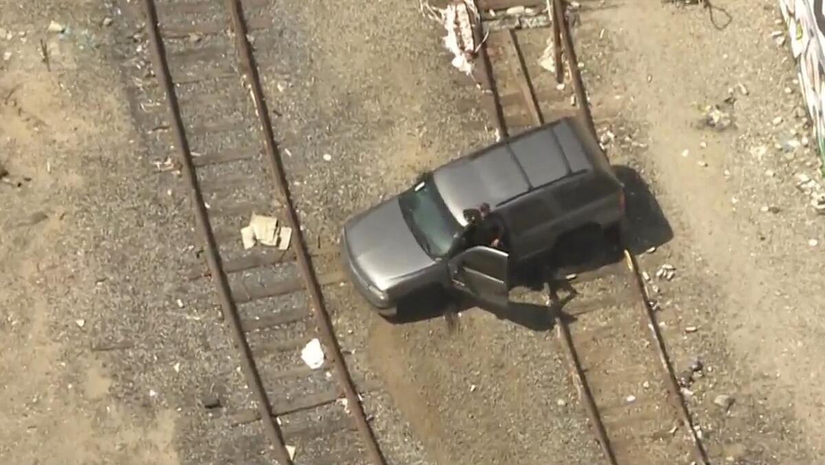 A black SUV sits on rail tracks
