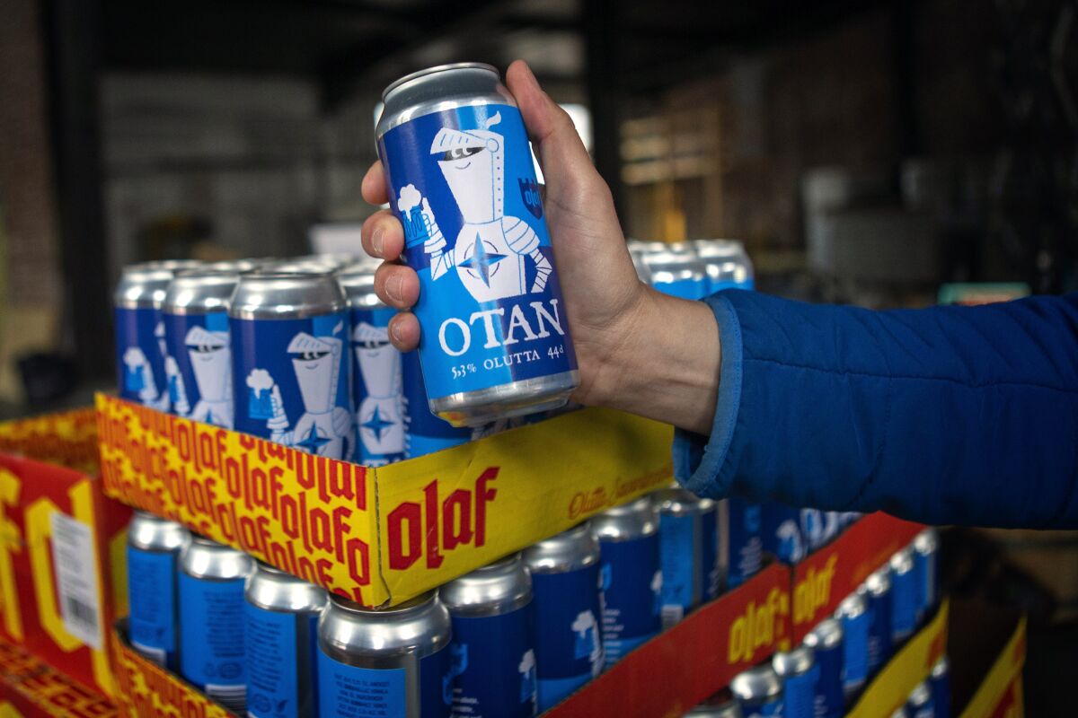 Beer cans with writing OTAN inspired by the North Atlantic Treaty Organization (NATO) logo by Olaf Brewing Company are displayed in Savonlinna, eastern Finland, Tuesday, May 17, 2022. Sweden on Tuesday signed a formal request to join NATO, a day after the country announced it would seek membership in the 30-member military alliance. In neighboring Finland, lawmakers are expected later in the day to formally endorse Finnish leaders’ decision also to join. The moves by the two Nordic countries, ending Sweden’s more than 200 years of military nonalignment and Finland’s nonalignment after World War II, have provoked the ire of the Kremlin. (Soila Puurtinen/Lehtikuva via AP)