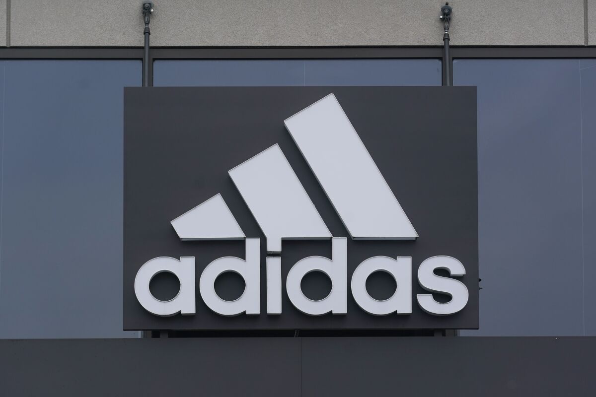 FILE - A sign is displayed in front of an Adidas retail store in Paramus, N.J., Oct. 25, 2022. Adidas says it is investigating allegations of inappropriate workplace conduct by the rapper formerly known as Kanye West that ex-employees made in an anonymous letter also accusing the German sportswear brand of looking the other way. (AP Photo/Seth Wenig)