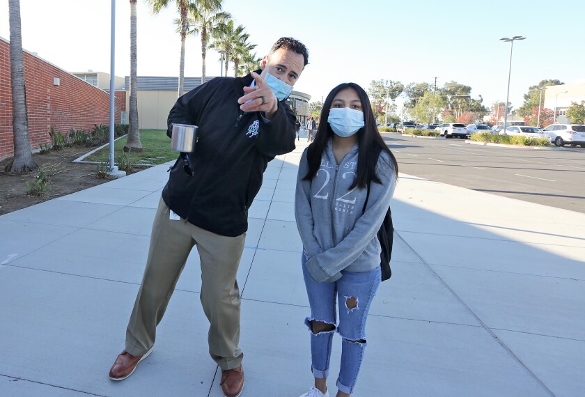 Principal Dr. Jacob Haley greets a student and steers her to her first class.