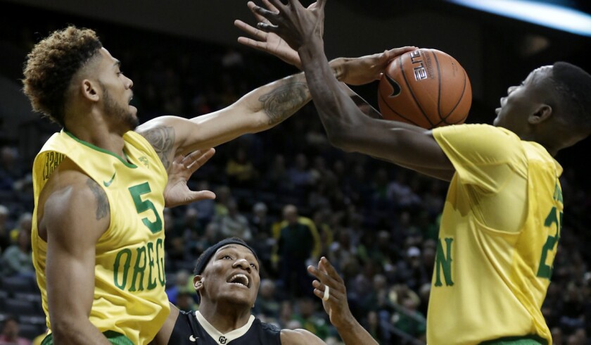 Oregon's Tyler Dorsey, left, pushes the rebound to Oregon's Chris Boucher, right, in front of Colorado's George King during the first half on Thursday.