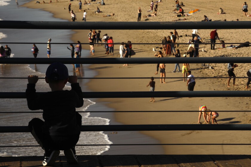 A child looks out over the beach from the Santa Monica Pier.