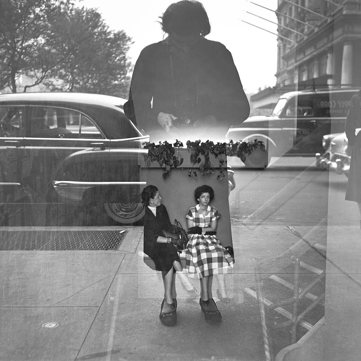 Vivian Maier is shown in silhouette whle photographing two seated women.