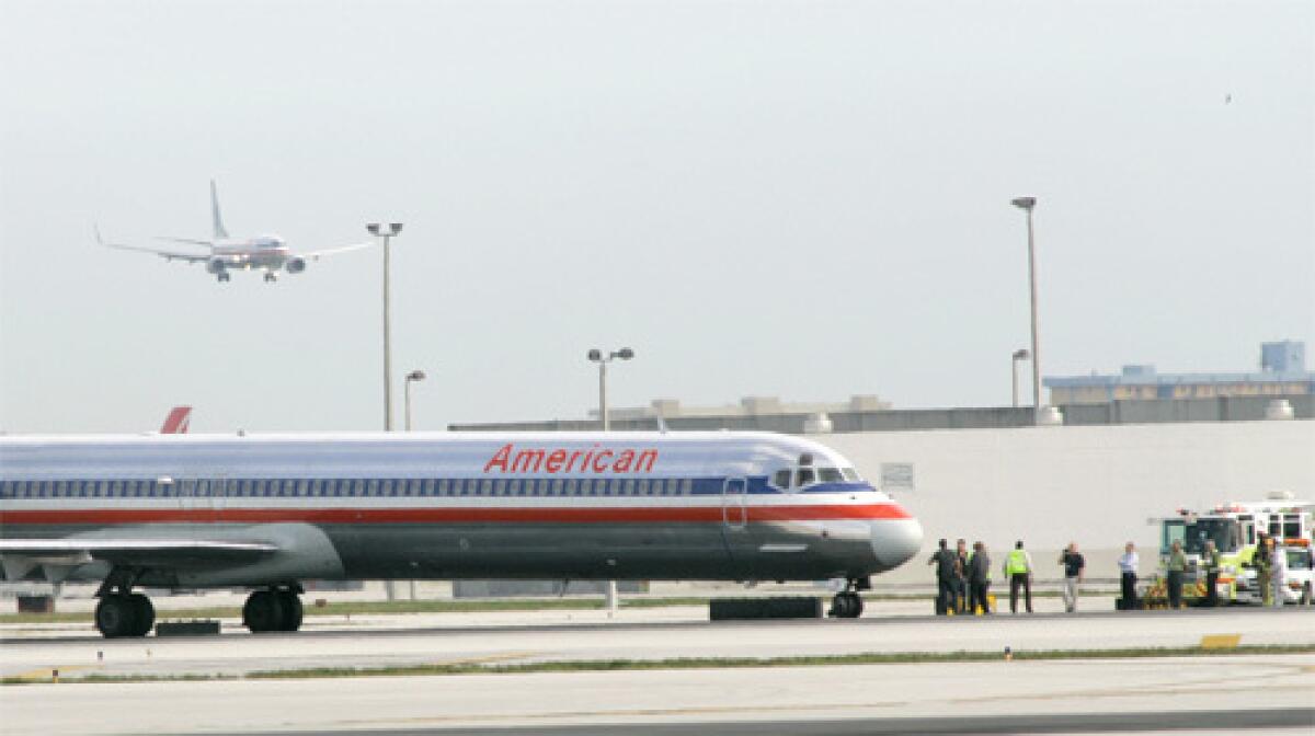 American Airlines MD-80 jet sits on the tarmac as fire rescue workers check the passenger plane at Miami International Airport.
