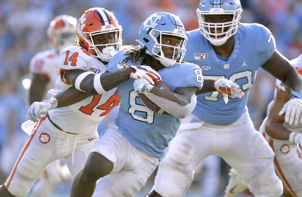 Clemson's Denzel Johnson (14) tackles North Carolina's Michael Carter (8) during the second half on Saturday in Chapel Hill, N.C. Clemson won 21-20.