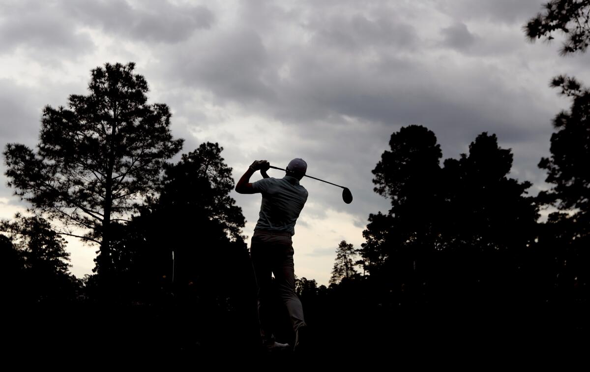 Storm clouds pass over as play resumes and Jordan Spieth tees off on the ninth hole during the third round of the Masters at Augusta National Golf Club on Saturday, April 10, 2021, in Augusta, Ga. (Curtis Compton/Atlanta Journal-Constitution via AP)