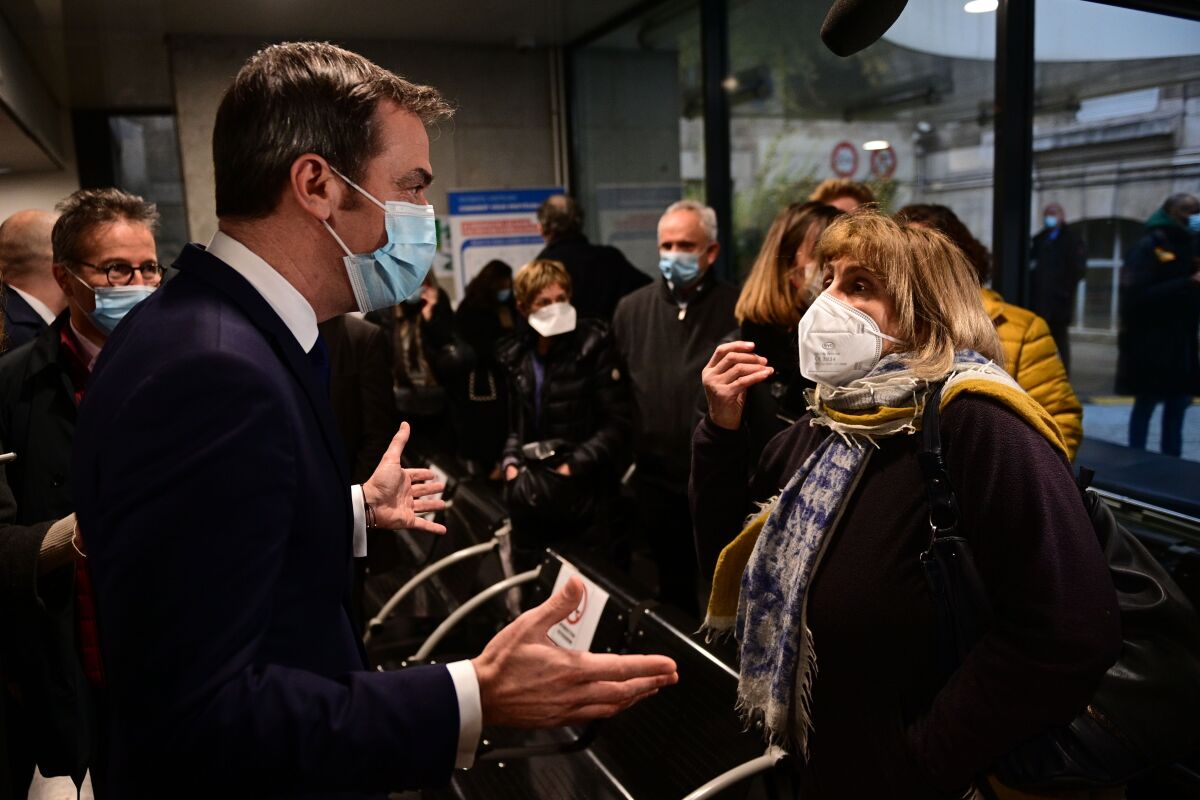 French Health Minister Olivier Veran talks to a woman as he arrives at the Hotel Dieu hospital in Paris on Monday.