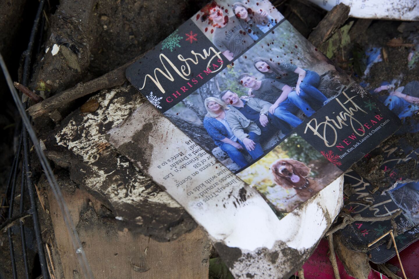 A Cantin family holiday card in a pile of debris in the 300 block of Hot Springs Road in Montecito. From left, Kim, mother who survived; father David, who was killed; son Jack, who is still missing; and daugher Lauren, who was pulled from the family home early Wednesday.