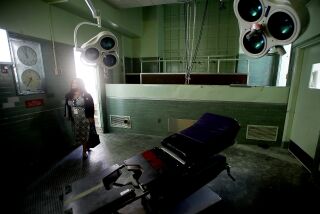 A visitor looks around an operating room in the Los Angeles County General Hospital.