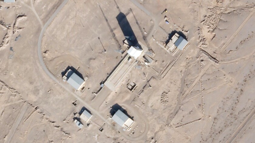 In this satellite photo by Planet Labs Inc., a support vehicle stands parked alongside a massive white gantry that typically houses a rocket on the launch pad as activity is seen at the Imam Khomeini Spaceport in Semnan province, Iran, Saturday, Dec. 11, 2021. Iran appears to be preparing for a space launch as negotiations continue in Vienna over its tattered nuclear deal with world powers, according to an expert and satellite images. (Planet Labs Inc. via AP)