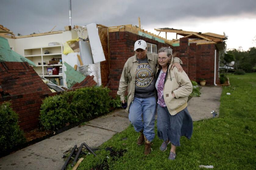 Karen Spencer is helped to her storm cellar by her daughter Tammi Foster in Peggs, Okla. Tuesday, May 21, 2019. Spencer's home was hit by an apparent tornado on Monday night. She and her husband Ed didn't have time to make it to the cellar on Monday and rode the storm out in their home. (Mike Simons/Tulsa World/Tulsa World via AP)
