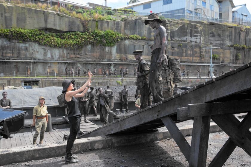 Director Angelina Jolie works with actors portraying prisoners on the Naoetsu set (River Bank Barge) of movie "Unbroken."