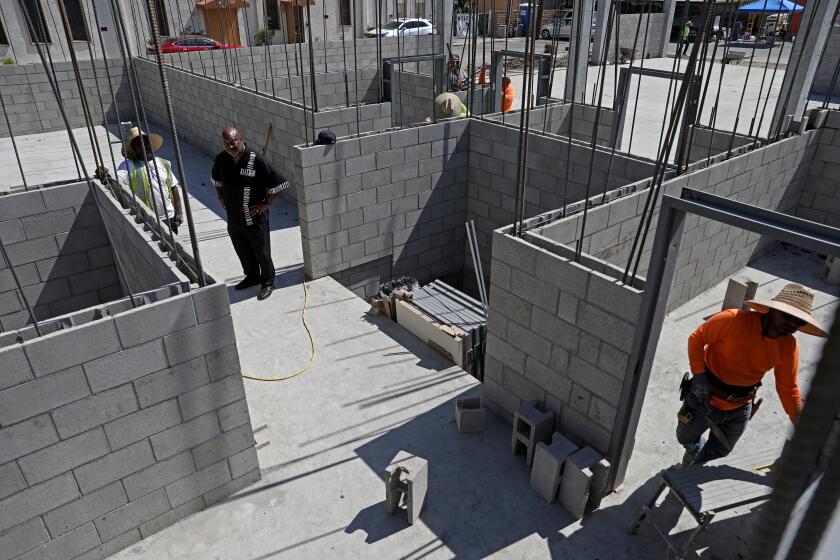 LOS ANGELES, CA - JULY 18: Rev. Kelvin Calloway, 69, second from left, senior pastor Bethel AME, at a permanent supportive housing complex under construction on the former parking lot of Bethel AME Church, along the 7900 block of S. Western Ave, on Tuesday, July 18, 2023 in Los Angeles, CA. Apartment buildings for homeless people financed with private capital by SDS Capital Group. (Gary Coronado / Los Angeles Times)