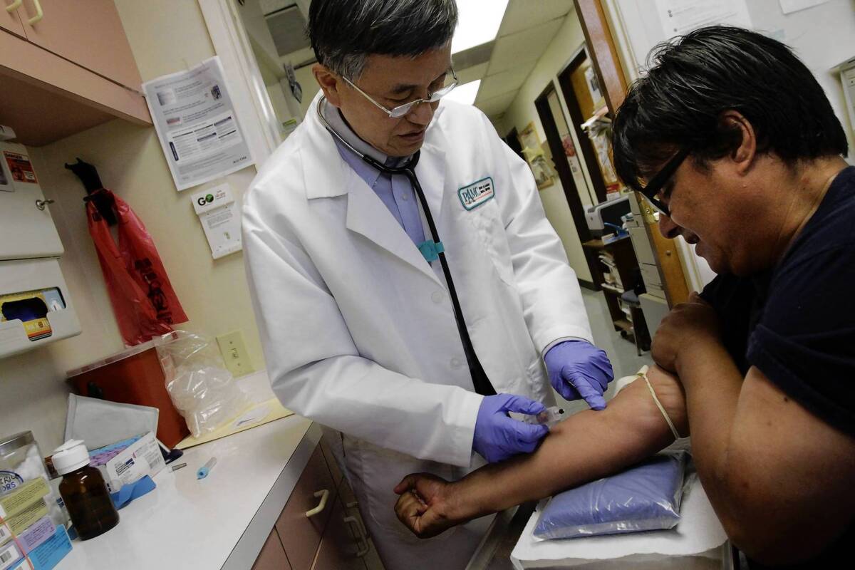 Dr George Ma draws blood from patient Ben Loya. Nearly three-quarters of his Chinatown office's patients are covered by Medi-Cal.