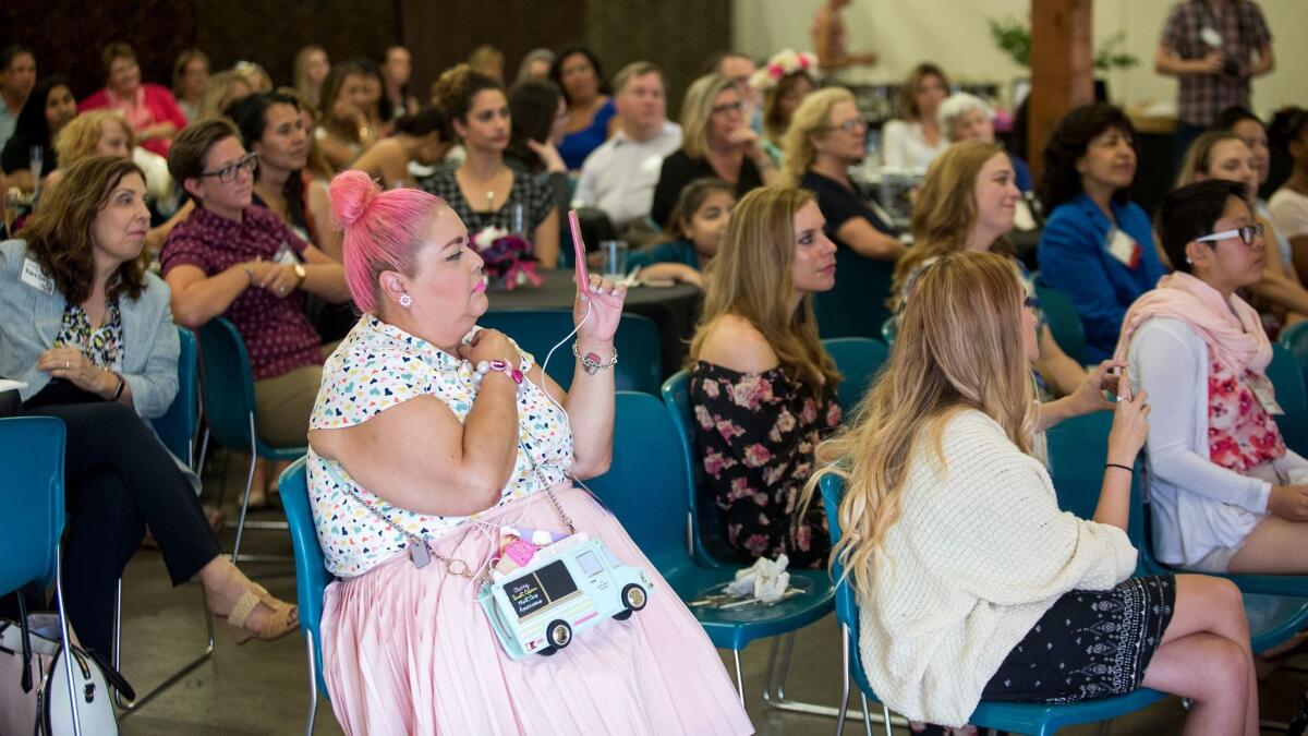 A fashion blogger shoots video of an interview with "Project Runway" Season 14 winner Ashley Nell Tipton at a Working Wardrobes event July 19.