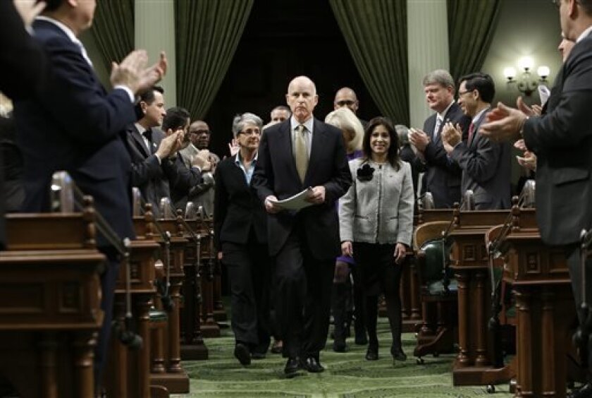 FILE - In this Jan. 24, 2013 file photo, lawmakers applaud Gov. Jerry Brown as he enters the Assembly Chambers to give his State of the State address at the Capitol in Sacramento, Calif. In his second stint as California's chief executive, Brown has received wide praise for bringing the state's massive budget deficit into line, but he also is seeking billions of dollars in infrastructure spending, which could lead to financial pitfalls for the state. (AP Photo/Rich Pedroncelli, File)