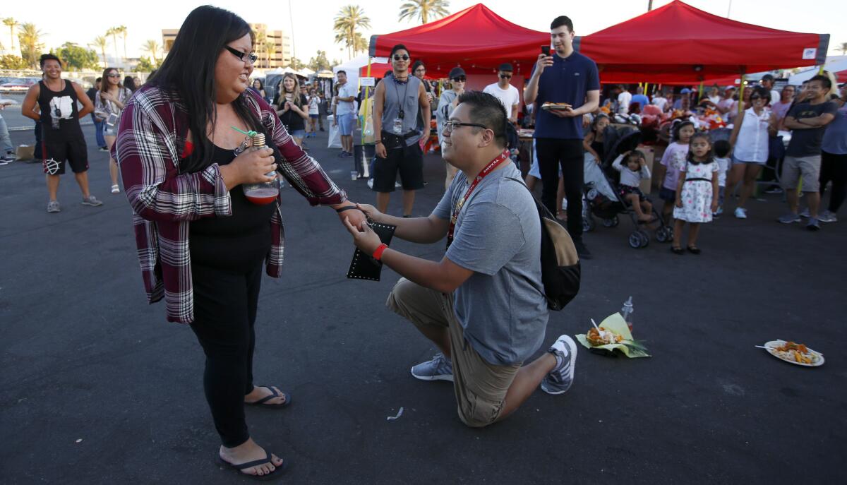 Lisa Thavisay listens while Steven Ham proposes at the 626 Night Market in Arcadia. (Francine Orr / Los Angeles Times)