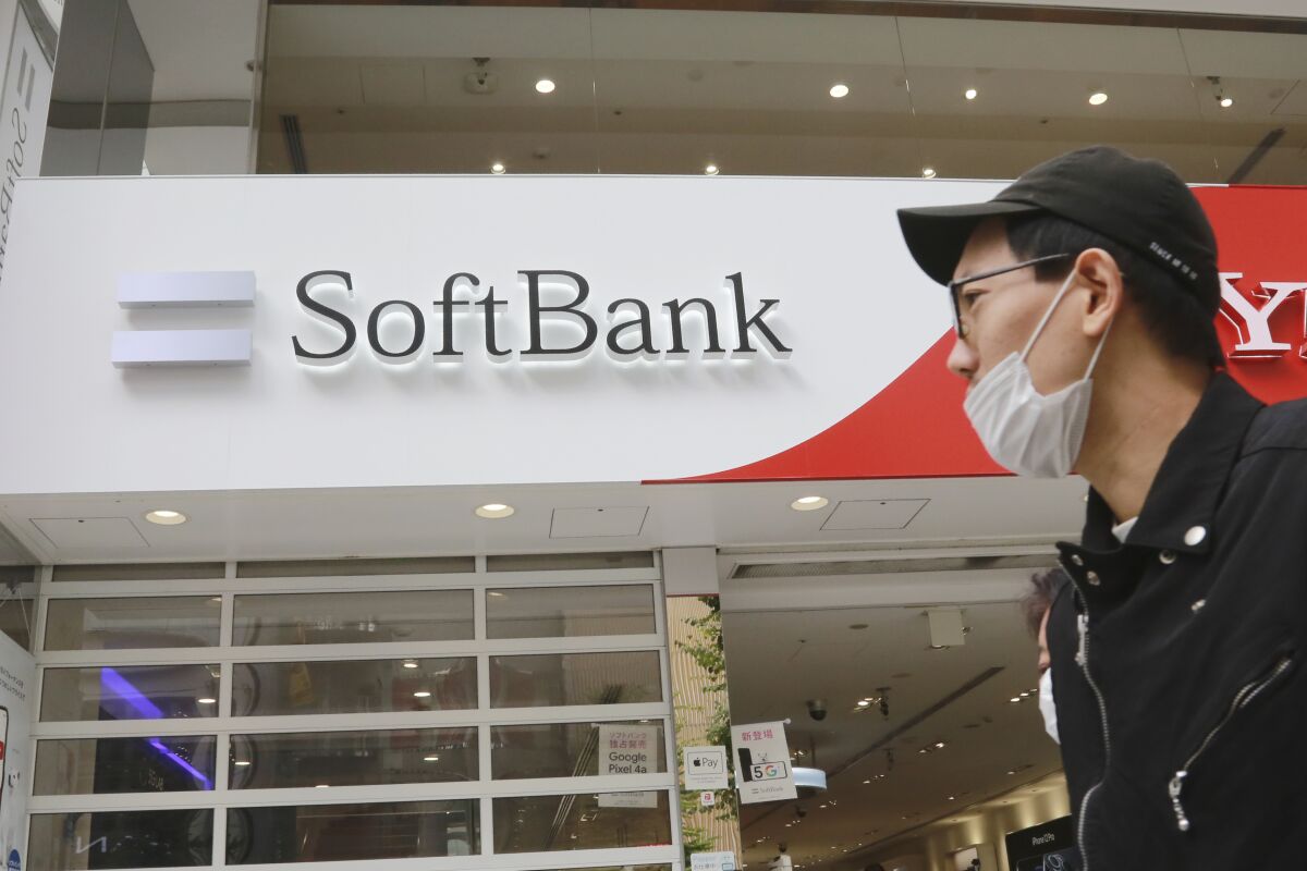 FILE - In this Nov. 9, 2020, file photo, people walk by a SoftBank shop in Tokyo. Japanese technology conglomerate SoftBank Group Corp. returned to profitability for the fiscal year that ended in March, boosted by the strong performance of its sprawling investments as stock prices surged, reported Wednesday, May 12, 2021. (AP Photo/Koji Sasahara, File)