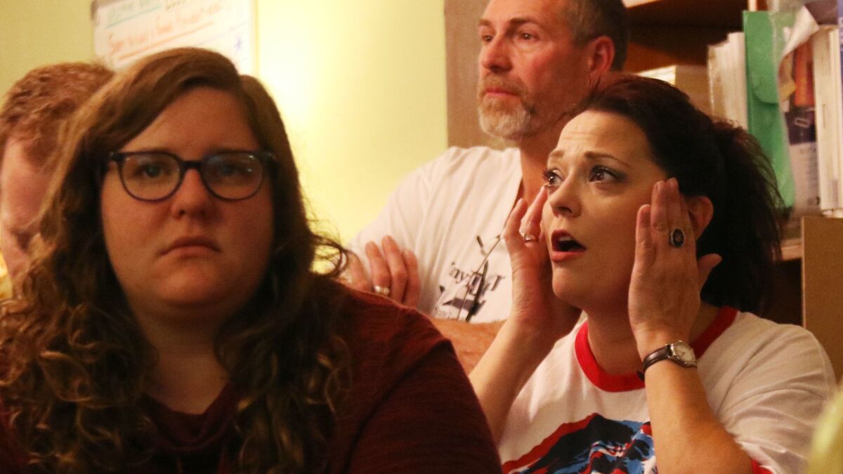 Debbie Santacroce, of West Bend, Wis., rubs the side of her head while watching election coverage at the Democratic Party of Washington County office on Nov. 8.